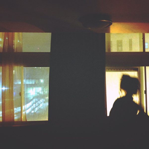 silhouette of woman standing in front of window